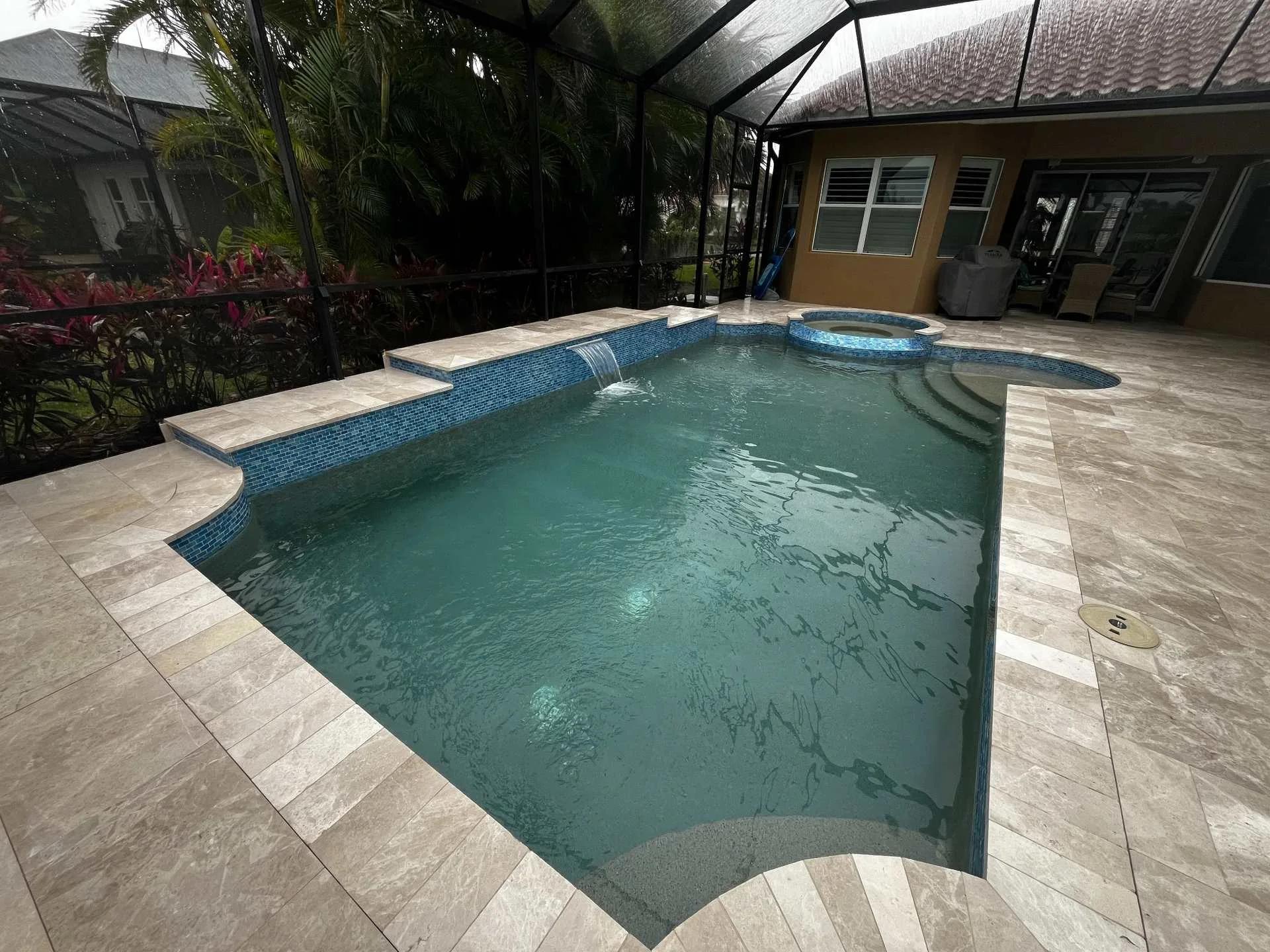 Pool with waterline tile and marble deck